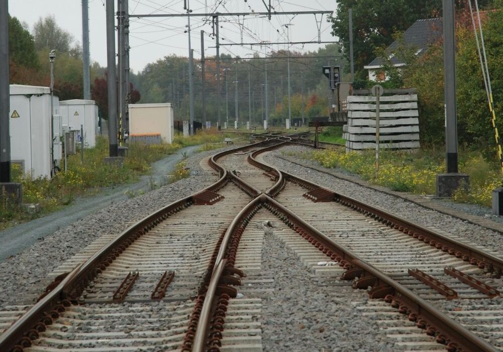 A curved railroad track switch in a rural or industrial setting.